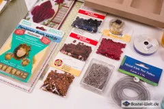 Detailausschnitt mit Bastelstanze, Glitter, Deko-Bändern und schwarzen Filz-Punchouts.